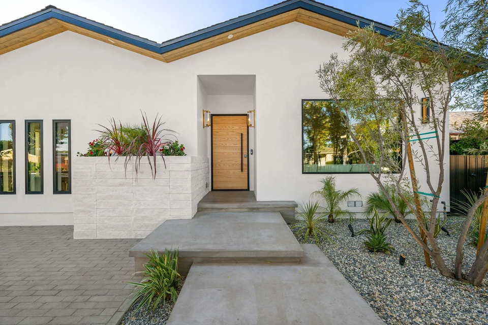 Technicien en combinaison bleue effectuant une intervention de serrurerie sur une porte d'entrée moderne