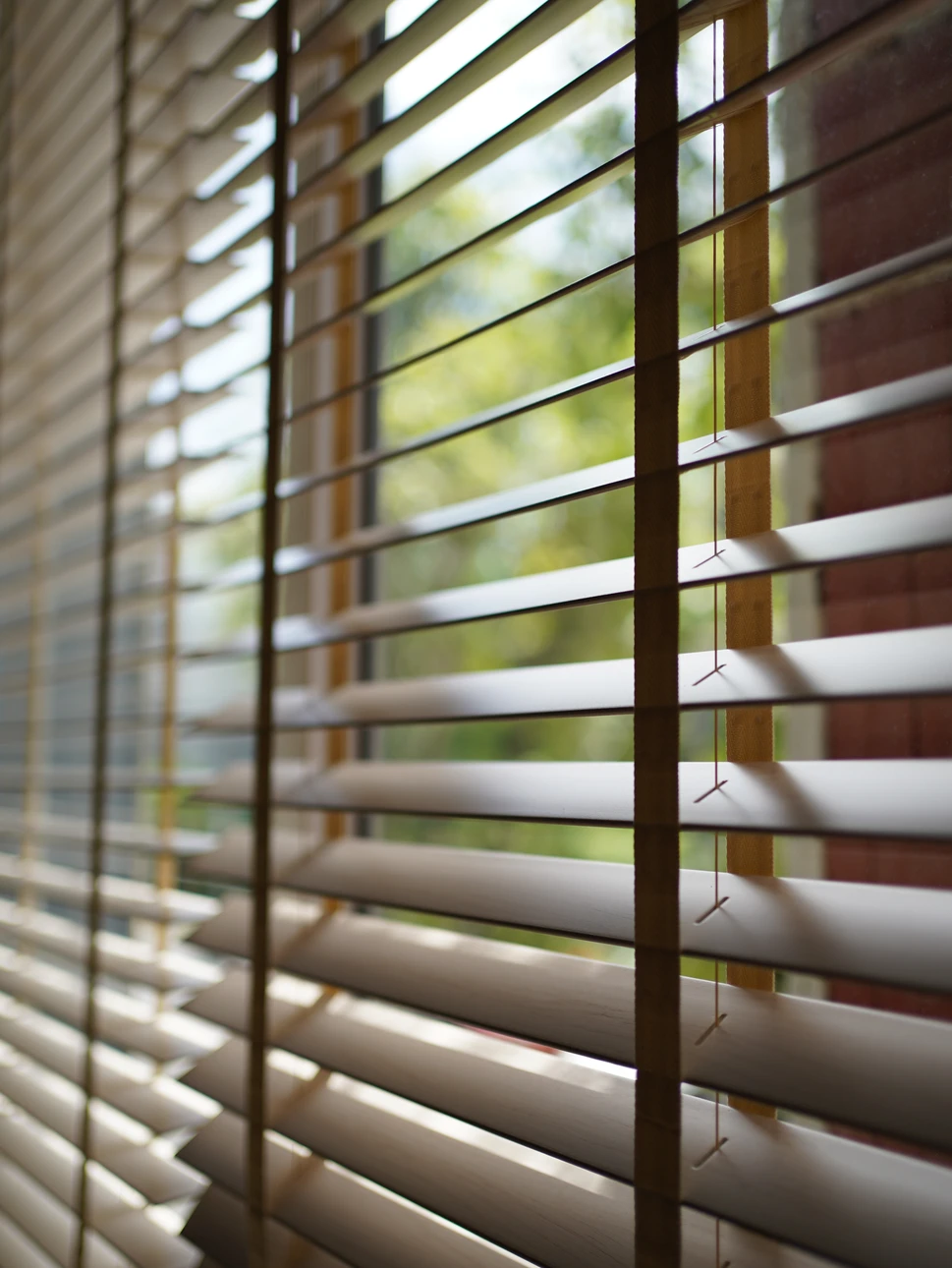 Atelier menuiserie intérieur avec artisan en salopette travaillant sur ordinateur portable, prenant notes avec crayon sur plans techniques