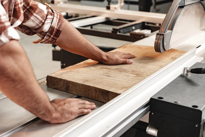 Atelier de menuiserie industrielle sous hangar métallique avec charpente apparente